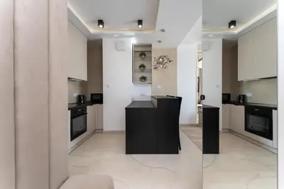 a kitchen with white cabinets and black appliances at Crystal Luxury Apartments Rakowicka in Kraków