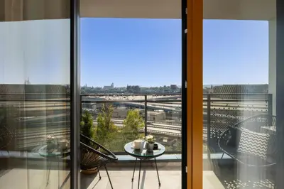 a balcony with a table and a view of a train at Crystal Luxury Apartments Rakowicka in Kraków
