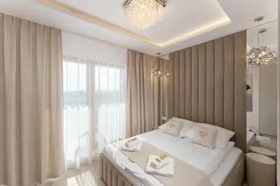 a bedroom with a large bed and a large window at Crystal Luxury Apartments Rakowicka in Kraków