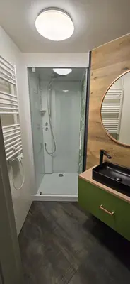 a bathroom with a shower with a sink and a mirror at Aqua Glamp in Jaszczurowa