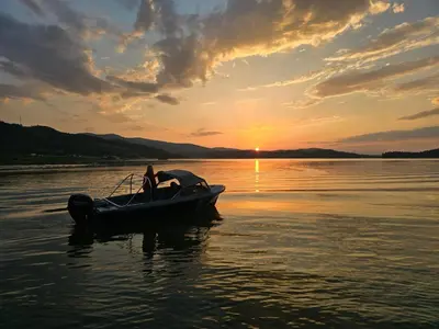 a person in a boat in the water at sunset at Aqua Glamp in Jaszczurowa
