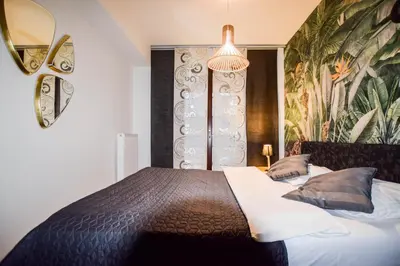 a bedroom with a bed and a wall with a painting at Apartament w centrum miasta, bezpłatny parking in Kraków
