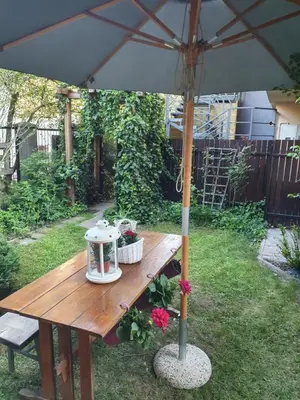 a picnic table with an umbrella in a yard at Bagry Rooms in Kraków