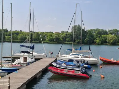 a group of boats are docked at a dock at Bagry Rooms in Kraków