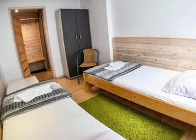 a bedroom with two beds and a closet at Bagry Rooms in Kraków