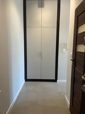 a closet with white doors in a room at Płaszowska Apartment in Kraków