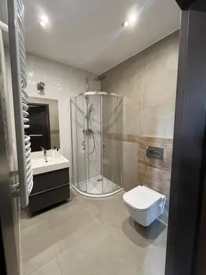 a bathroom with a shower and a toilet and a sink at Płaszowska Apartment in Kraków