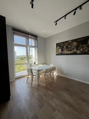 a dining room with a table and chairs and a window at Płaszowska Apartment in Kraków
