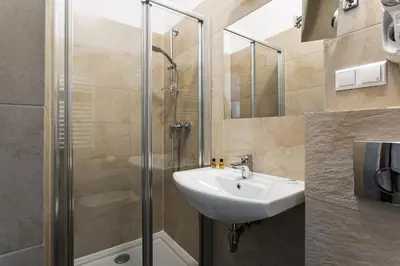 a bathroom with a sink and a shower at Grodzka Royal Apartments in Kraków