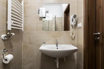 a bathroom with a sink and a mirror at Grodzka Royal Apartments in Kraków