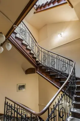 a winding staircase in a house with wooden railings at Grodzka Royal Apartments in Kraków