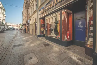 a city street with a bunch of store fronts at Grodzka Royal Apartments in Kraków