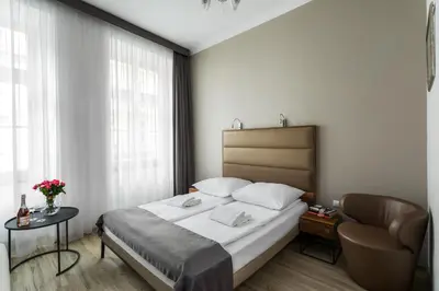 a hotel room with a bed and a chair at Grodzka Royal Apartments in Kraków