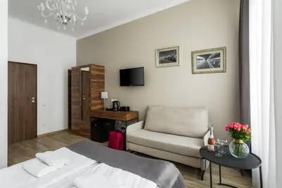 a bedroom with a bed and a chair and a table at Grodzka Royal Apartments in Kraków