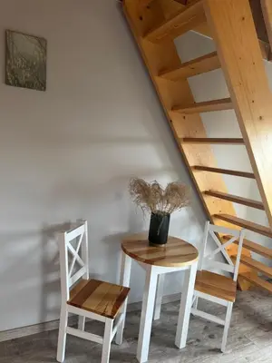 a table and two chairs next to a staircase at Mecenasówka Noclegi in Zawoja