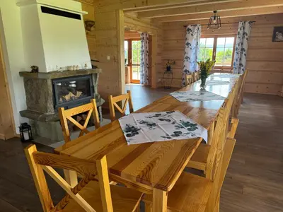 a dining room with a table and a fireplace at Mecenasówka Noclegi in Zawoja