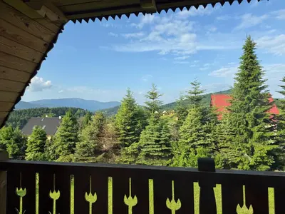 a view from the balcony of a house with trees at Mecenasówka Noclegi in Zawoja