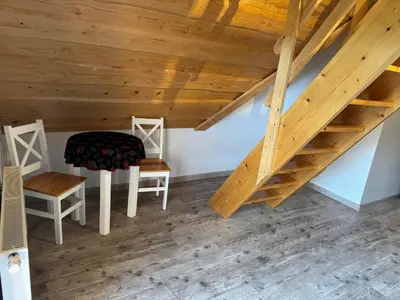 a room with two chairs and a wooden stairs at Mecenasówka Noclegi in Zawoja