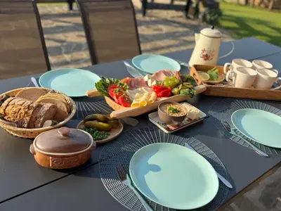 a table with blue plates and food on it at Mecenasówka Noclegi in Zawoja
