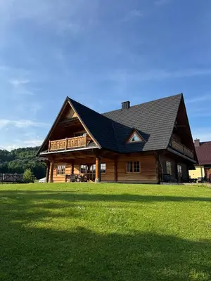 a large wooden house with a gambrel roof at Mecenasówka Noclegi in Zawoja