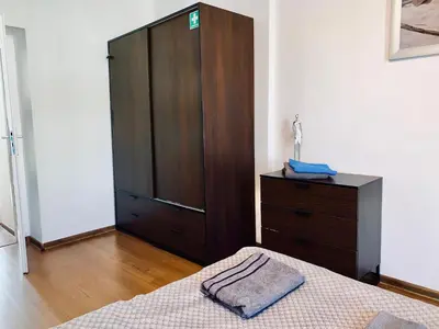 a bedroom with a bed and a wooden cabinet at Apartament w centrum in Kraków