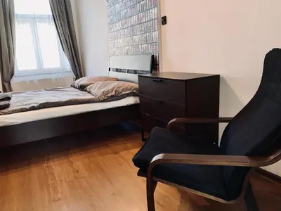 a bedroom with a bed and a chair and a dresser at Apartament w centrum in Kraków