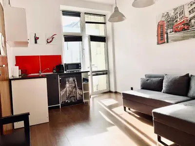 a living room with a couch and a kitchen at Apartament w centrum in Kraków