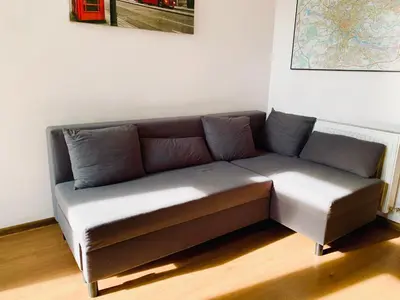 a brown couch sitting in a room with a wall at Apartament w centrum in Kraków