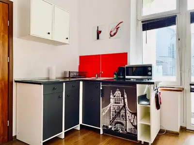 a kitchen with white cabinets and a counter with a microwave at Apartament w centrum in Kraków