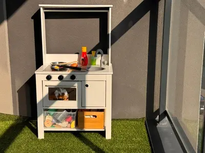 a toy kitchen with a pretend stove in the grass at Family Apartment Krakow Błonia in Kraków