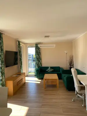 a living room with a green couch and a table at Family Apartment Krakow Błonia in Kraków