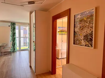 a hallway with a painting on the wall and a doorway at Family Apartment Krakow Błonia in Kraków
