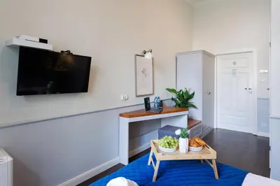 a living room with a table and a tv at Malila Premium Aparthotel Sebastiana 20 Old Town in Kraków