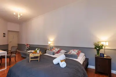 a bedroom with two beds and a living room at Malila Premium Aparthotel Sebastiana 20 Old Town in Kraków