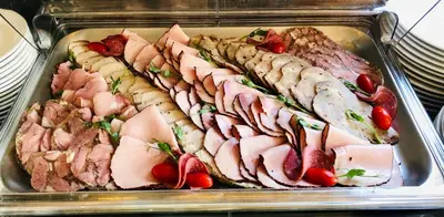 a tray of different types of meat and vegetables at Hotel Szary Residence in Michałowice