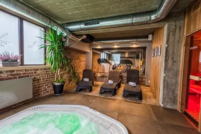 a hot tub in the middle of a room with chairs at Hotel Szary Residence in Michałowice
