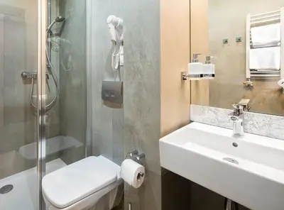 a bathroom with a sink and a toilet and a shower at Hotel Szary Residence in Michałowice