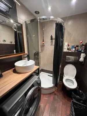 a bathroom with a toilet and a sink and a washing machine at Lets go in Kraków