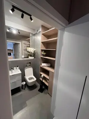 a bathroom with a white toilet and a sink at Apartament Dominikanów 28m36 in Kraków