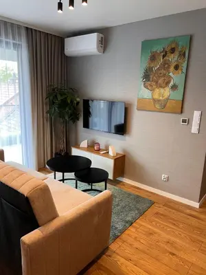a living room with a couch and a flat screen tv at Apartament Dominikanów 28m36 in Kraków
