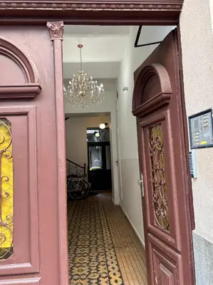 a door leading into a hallway with a chandelier at Przytulne mieszkania na wynajem in Kraków