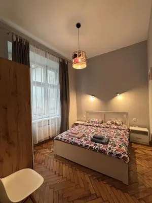 a bedroom with a bed and a large window at Przytulne mieszkania na wynajem in Kraków