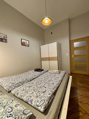 a bedroom with two beds and a refrigerator at Przytulne mieszkania na wynajem in Kraków