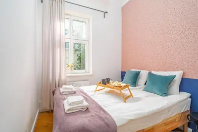 a small bedroom with a bed with a table on it at Kraków Dębniki - Vistula River & Parks nearby in Kraków