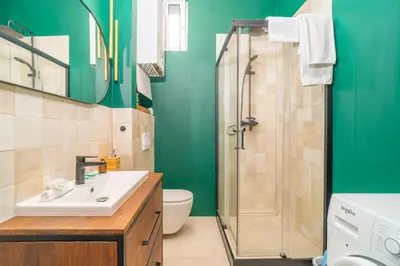a green bathroom with a sink and a shower at Kraków Dębniki - Vistula River & Parks nearby in Kraków