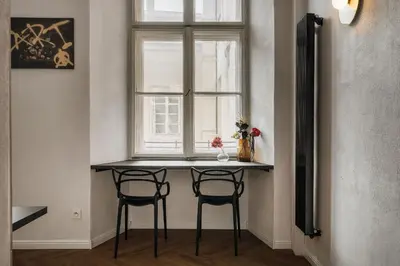 a table with two chairs in front of a window at dreamfactory - Hostel Krakow in Kraków