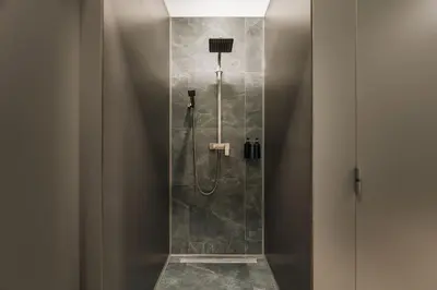 a bathroom with a shower with a glass door at dreamfactory - Hostel Krakow in Kraków
