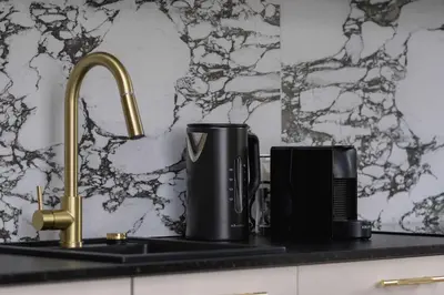 a kitchen counter with a sink with a coffee maker at Modern Prestige Apartment with Parking in Kraków by Noclegi Renters in Kraków