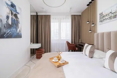 a hotel room with a large bed and a desk at Modern Prestige Apartment with Parking in Kraków by Noclegi Renters in Kraków