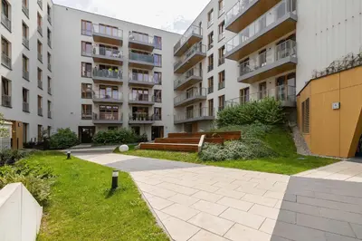 a courtyard of an apartment building with a bench at Modern Prestige Apartment with Parking in Kraków by Noclegi Renters in Kraków